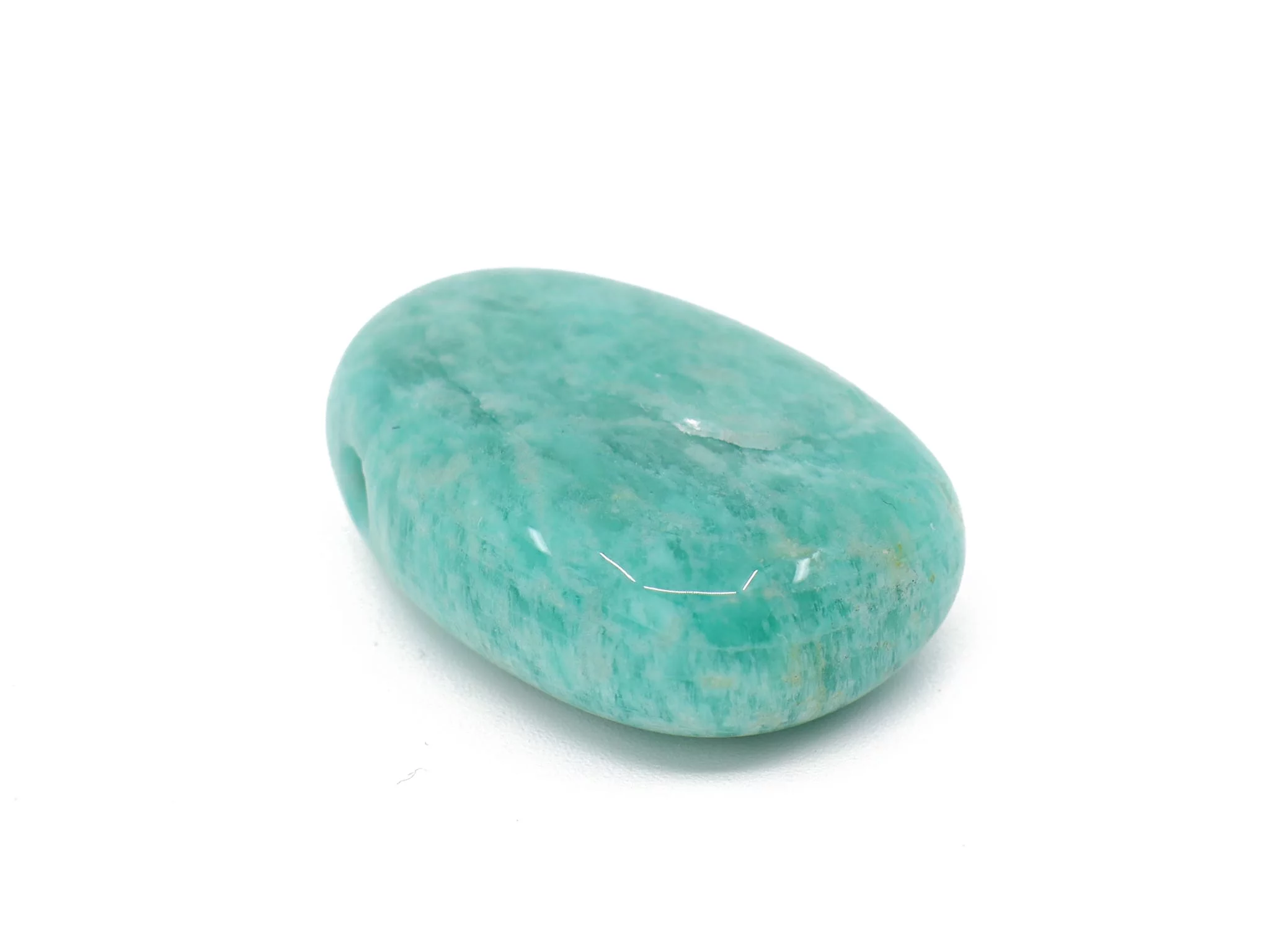 Amazonite gemstone pendant as a lying polished tumbled stone with visible drill hole