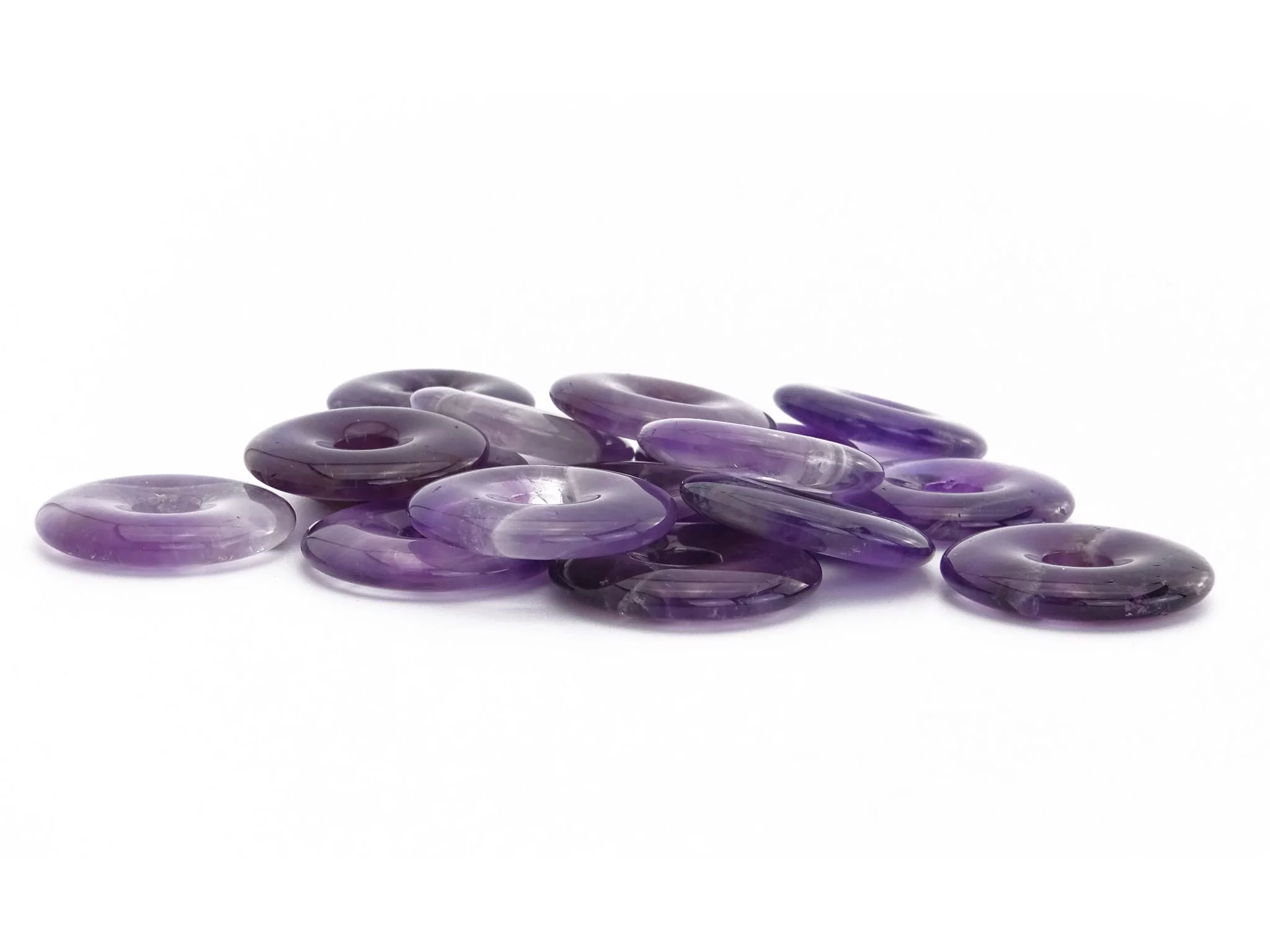 Pendentif donut améthyste comme sélection de plusieurs pierres ornementales violettes en vue latérale