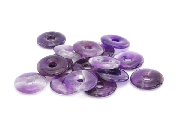 Pendentif donut améthyste comme groupe de pierres donut violettes polies sur fond blanc