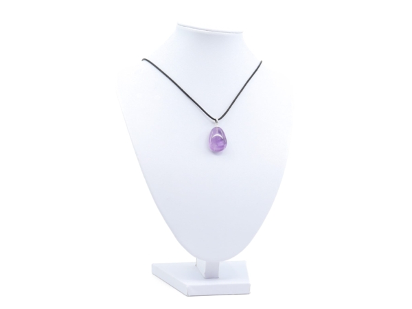 Amethyst gemstone pendant as necklace on white jewelry bust with black cord