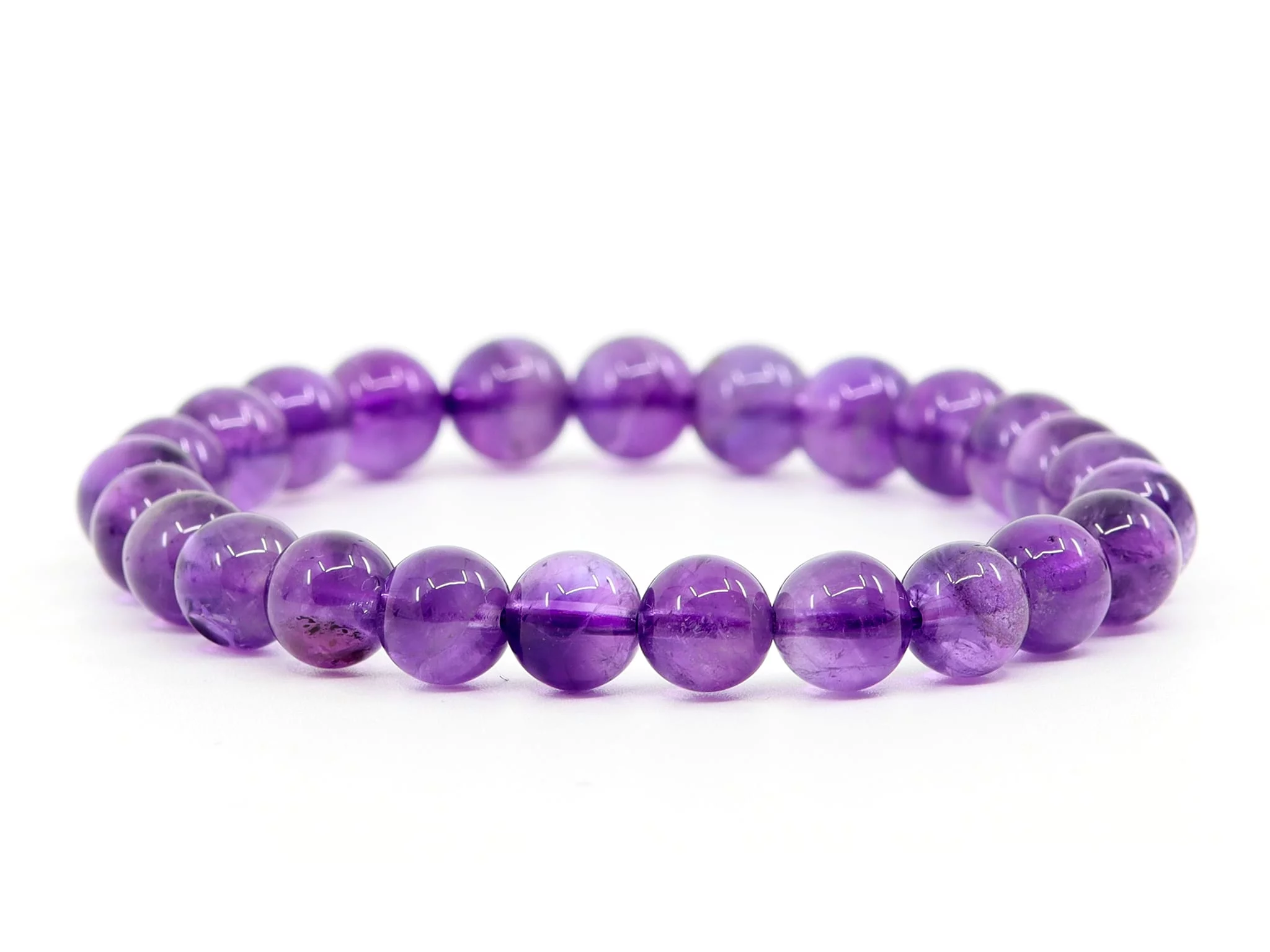 Amethyst gemstone bracelet with purple beads on white background in full view