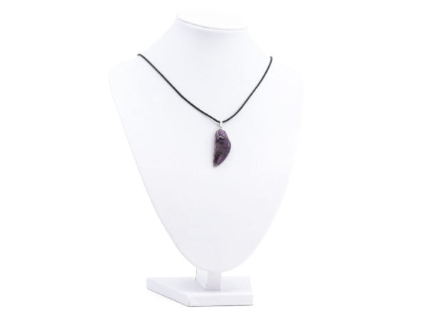 Pendentif aile d’ange en améthyste sur collier noir sur un buste à bijoux blanc
