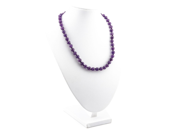 Amethyst necklace with violet beads on a white jewelry bust in a worn view