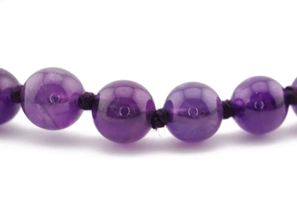 Amethyst Halskette mit runden violetten Naturstein-Kugeln und dunkler Kordel im Detail