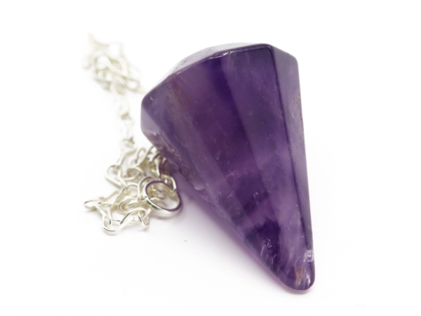 Pendule en améthyste avec chaîne, gros plan sur la surface violette facettée de la pierre et la suspension