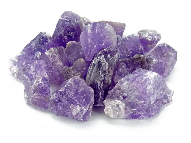 Amethyst Wassersteine als violette naturbelassene Rohsteine in dichter Anordnung auf weissem Hintergrund