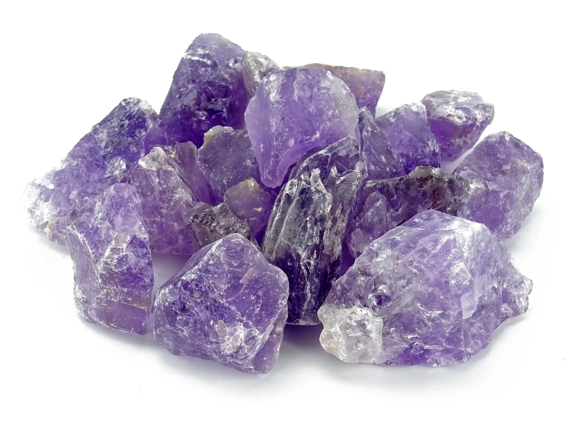 Amethyst Wassersteine als violette naturbelassene Rohsteine in dichter Anordnung auf weissem Hintergrund