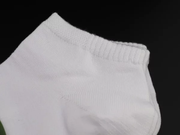 Bambus Sneaker Socken in Weiss mit Detailansicht des gerippten Abschlussbunds auf schwarzem Hintergrund