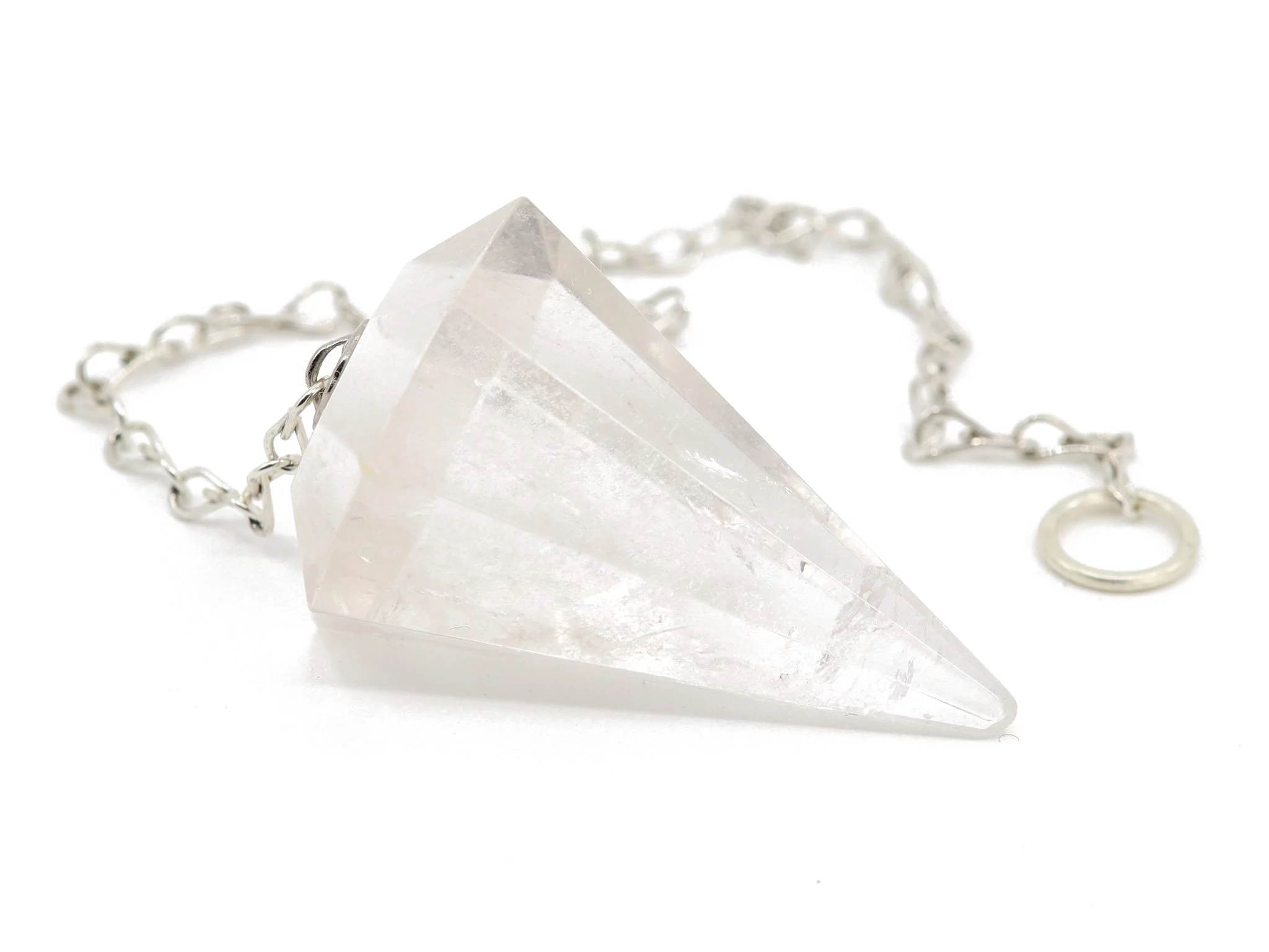 Clear quartz pendulum with faceted point and silver-colored link chain in close-up