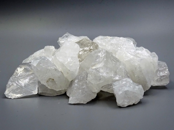 Rock crystal water stones with irregular raw stone surface on a gray background