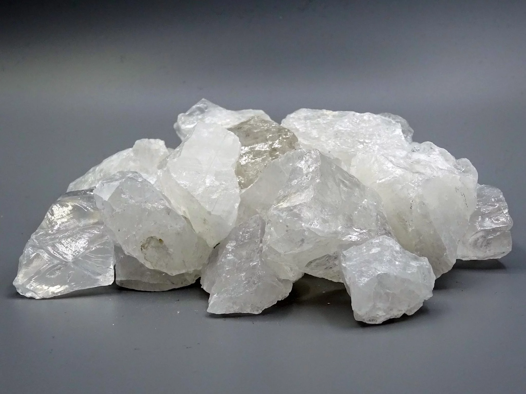 Rock crystal water stones with irregular raw stone surface on a gray background