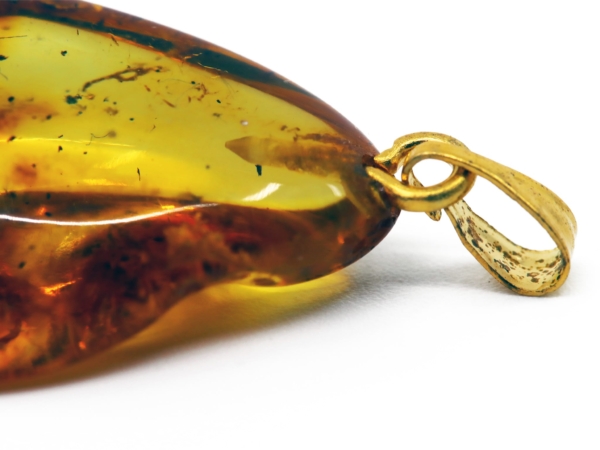 Amber pendant detail view of the gold-colored brass loop on the transparent stone