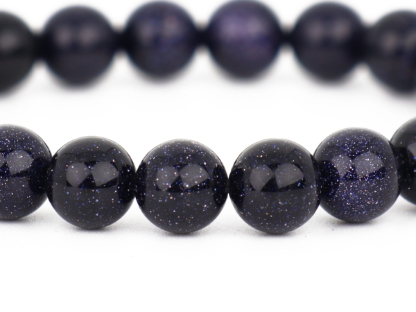 Blue Goldstone bracelet close-up of the shiny dark blue glass beads with shimmer effect