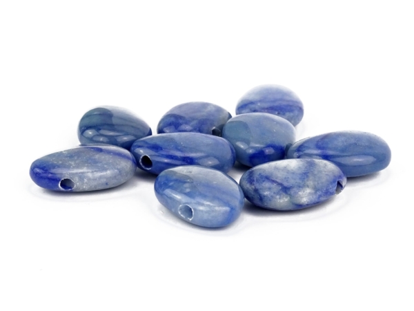 Blue quartz gemstone pendant as a close-up of several polished blue drilled stones