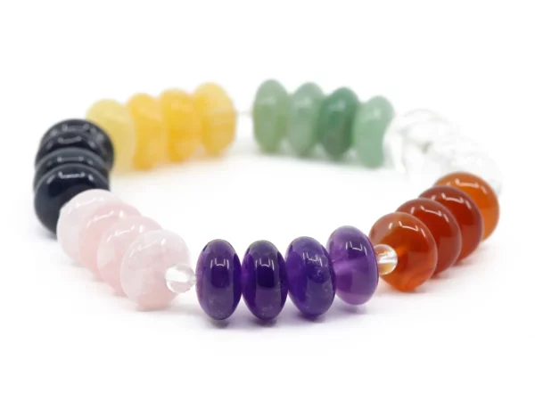 Chakra Edelsteinarmband mit polierten Perlen in sieben Farben auf weissem Hintergrund