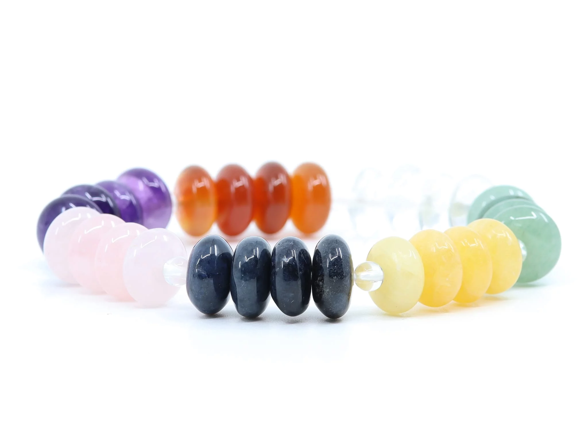 Chakra Edelsteinarmband mit sieben farbigen, glänzend polierten Steinperlen im Detail