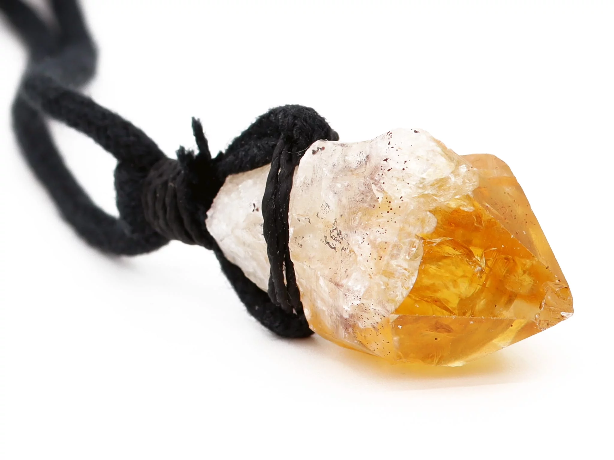 Citrine crystal pendant close-up with a crystalline yellow-orange surface and fabric cord