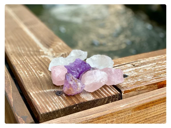 Edelstein Wasserstein Trinkset mit Amethyst, Bergkristall und Rosenquarz auf rustikalem Holz