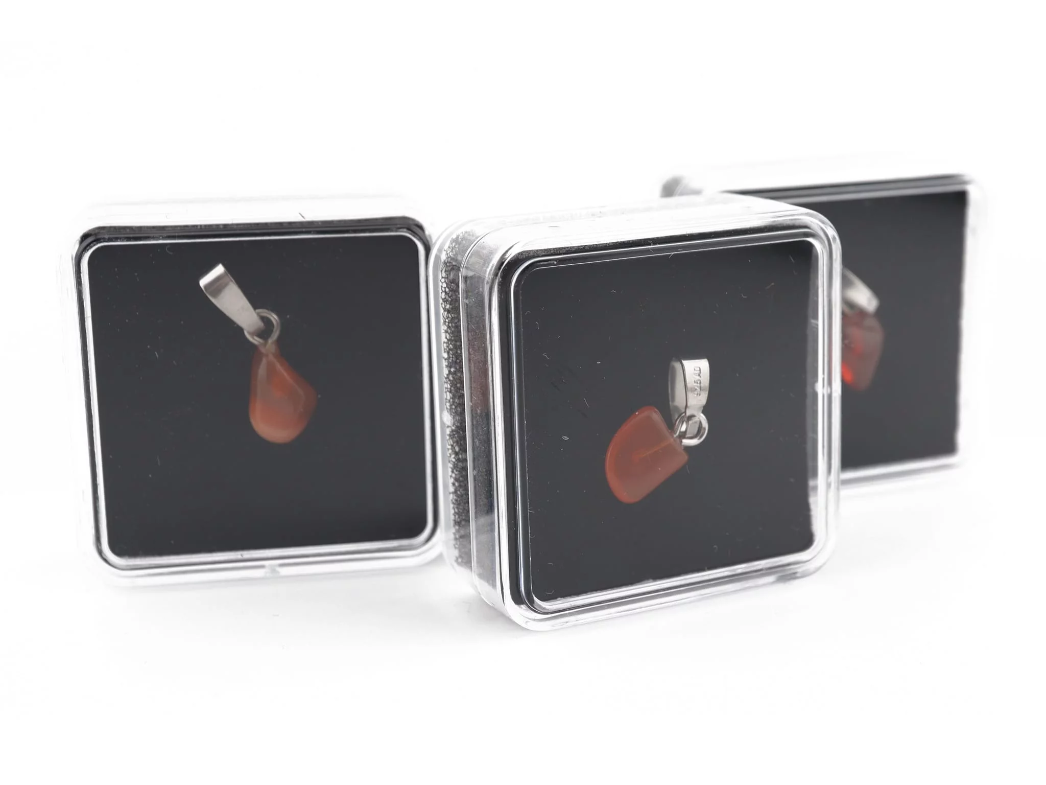 Fire opal gemstone pendant in a transparent presentation box with dark insert