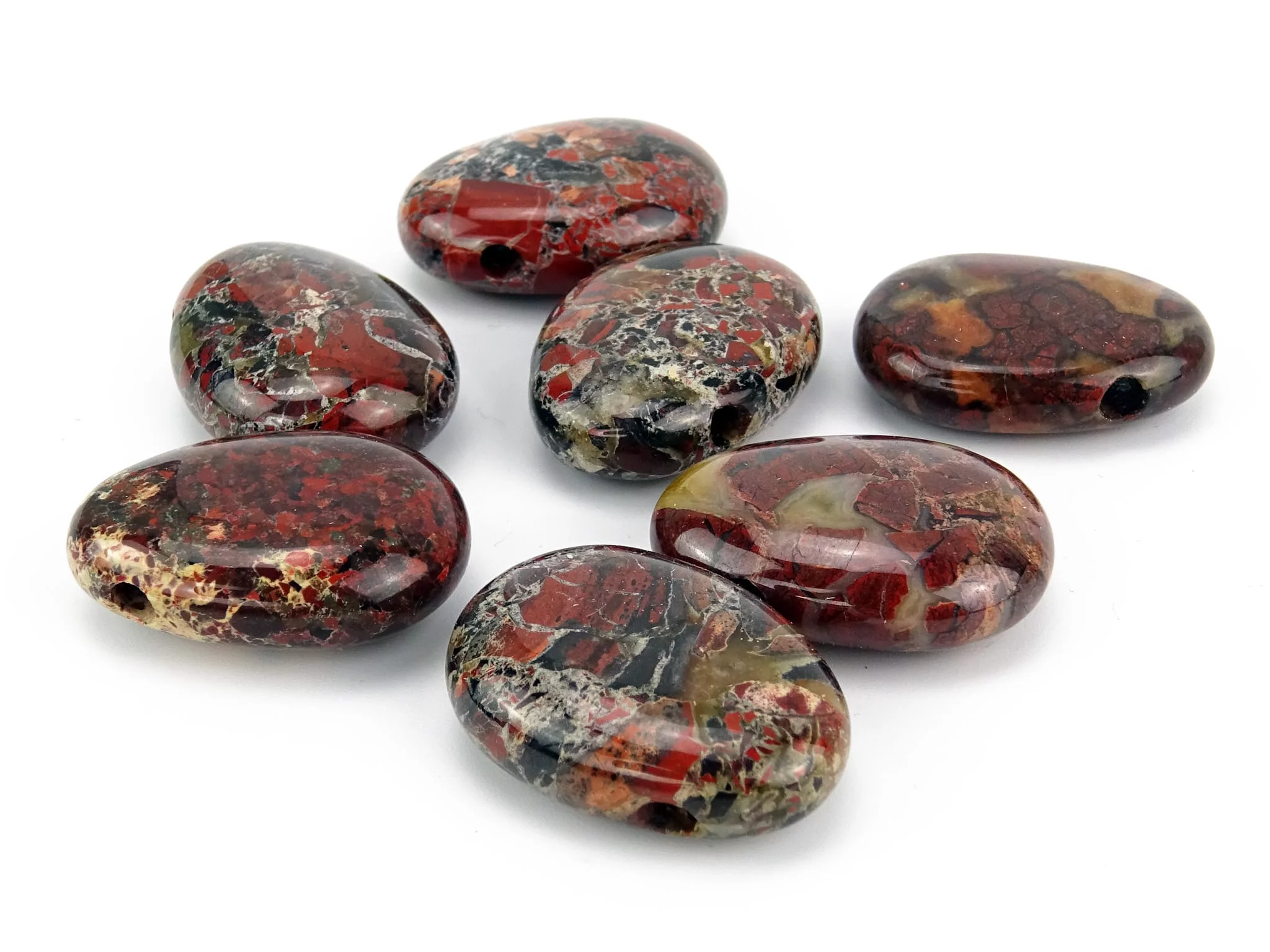 Pendentif en rhyolite fleur parmi une sélection de pierres percées aux motifs variés