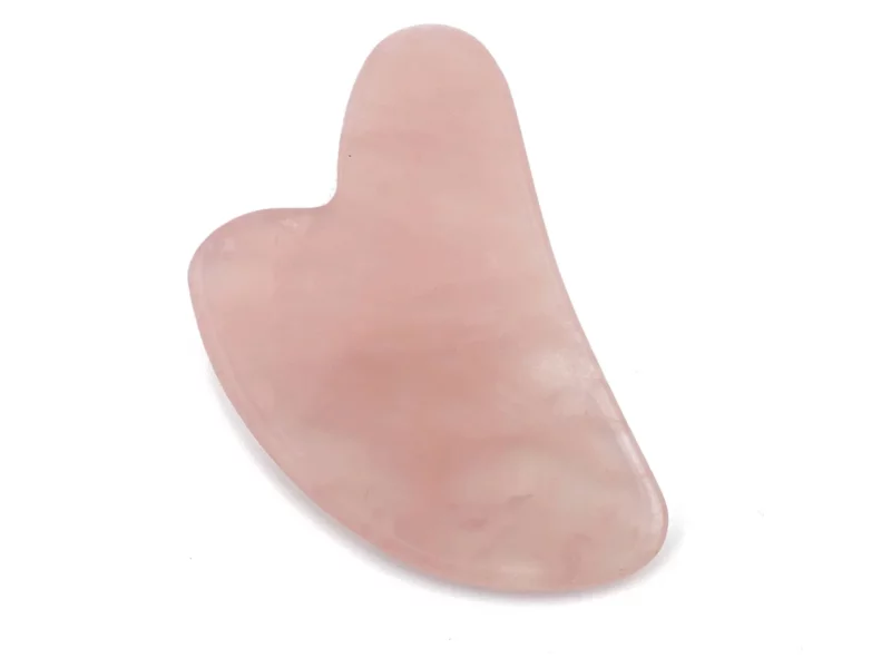 Rosenquarz Gua Sha Massagestein in zartem Rosa mit glatt polierter, geschwungener Form auf Weiss