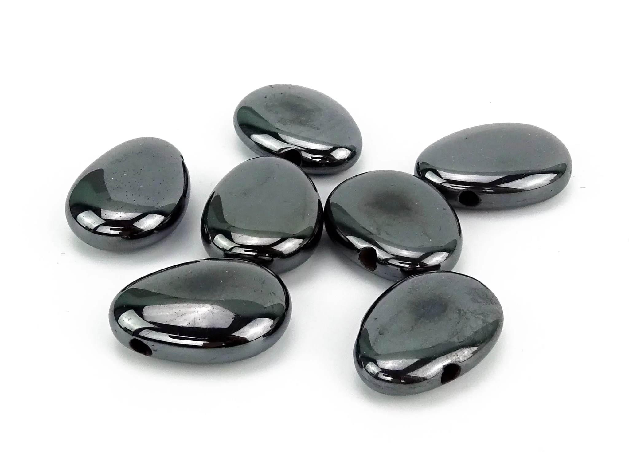 Pierres percées en hématite avec perforations visibles sur fond blanc