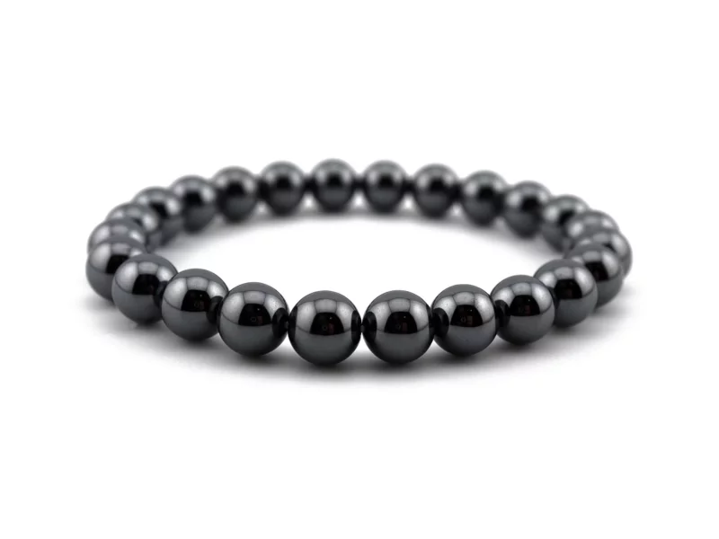 Hematite gemstone bracelet with shiny dark gray beads in diagonal front view on white background