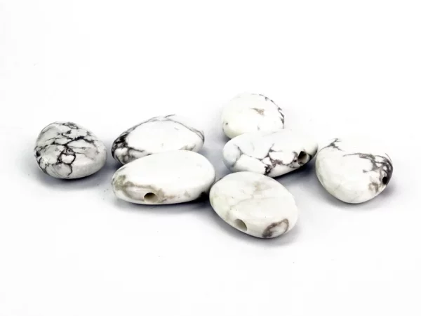 Howlite Lochsteine mit sichtbaren Bohrungen auf weissem Hintergrund