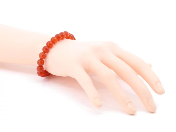 Karneol Edelsteinarmband als Trageansicht am Handgelenk mit roten polierten Kugeln