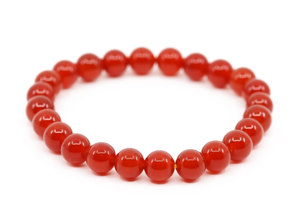 Carnelian gemstone bracelet with red round-cut beads in slightly elevated view