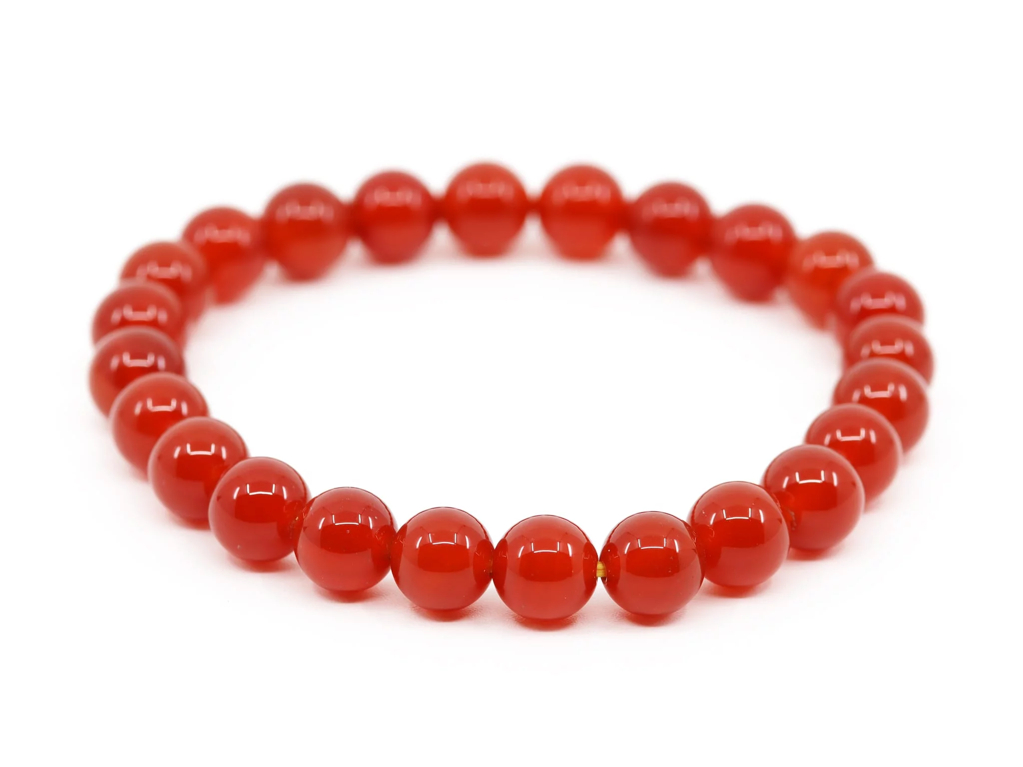 Carnelian gemstone bracelet with red round-cut beads in slightly elevated view