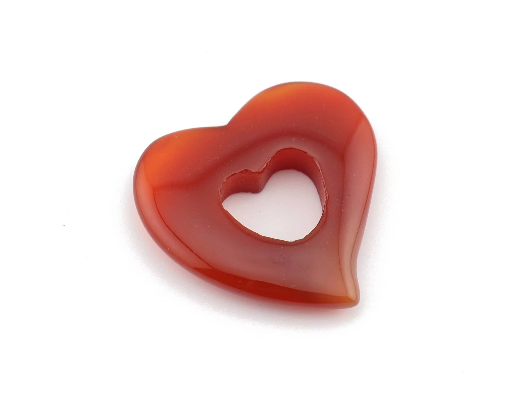 Pendentif cœur en cornaline en gros plan avec une surface polie rouge-orangé