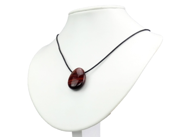 Pendentif en pierre précieuse Œil de chat comme collier sur un présentoir de bijoux blanc