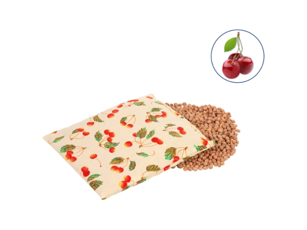 Cherry stone pillow with cherry cover in a diagonal view next to an open layer of cherry stones