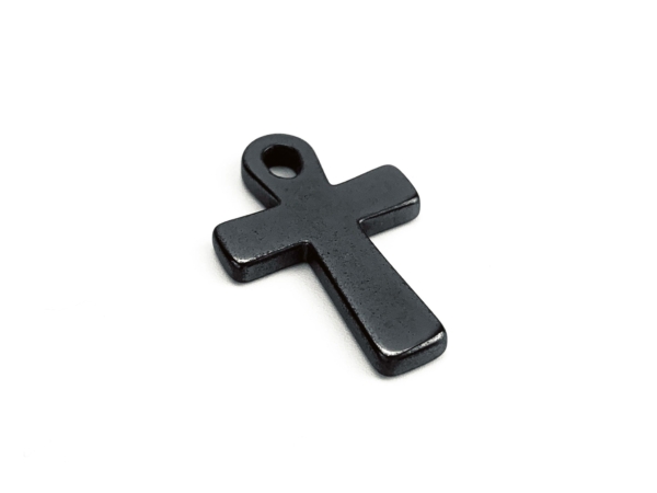 Pendentif croix en hématine en vue détaillée oblique avec surface sombre