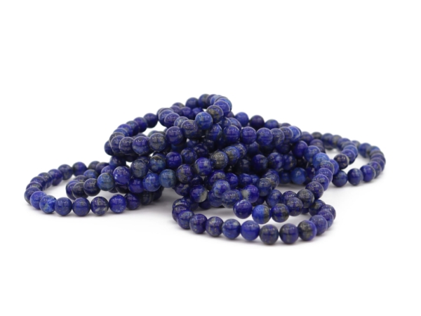 Bracciali in lapislazzuli con sfere blu scuro levigate, gruppo di prodotti su sfondo bianco