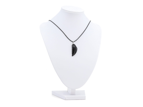 Pendentif aile d’ange en onyx en collier sur un buste à bijoux blanc, vue d’ensemble