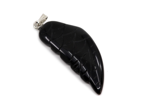 Pendentif aile d’ange en onyx en gros plan avec surface noire brillante et relief de plume