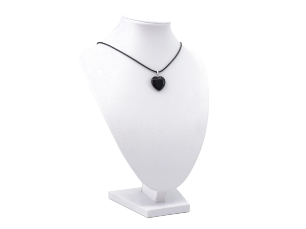 Ciondolo in onice a cuore visto come collana su un busto per gioielli bianco
