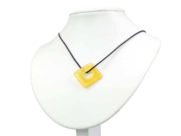 Pendentif calcite orange Square Donut avec collier noir sur buste à bijoux blanc