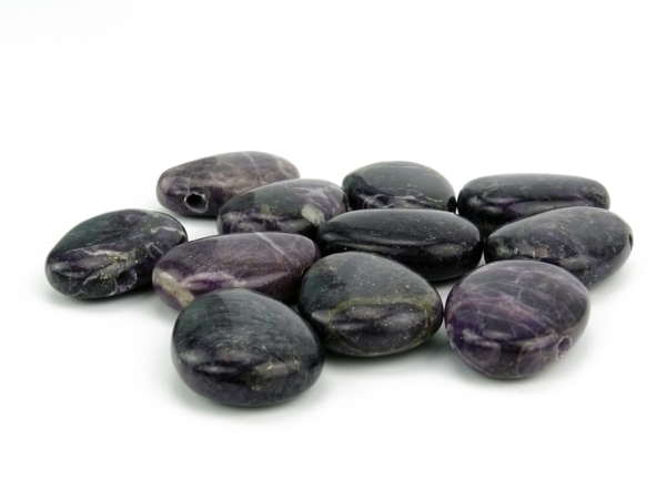 Purple Heart gemstone pendant as a selection of polished violet drilled stones on a white background