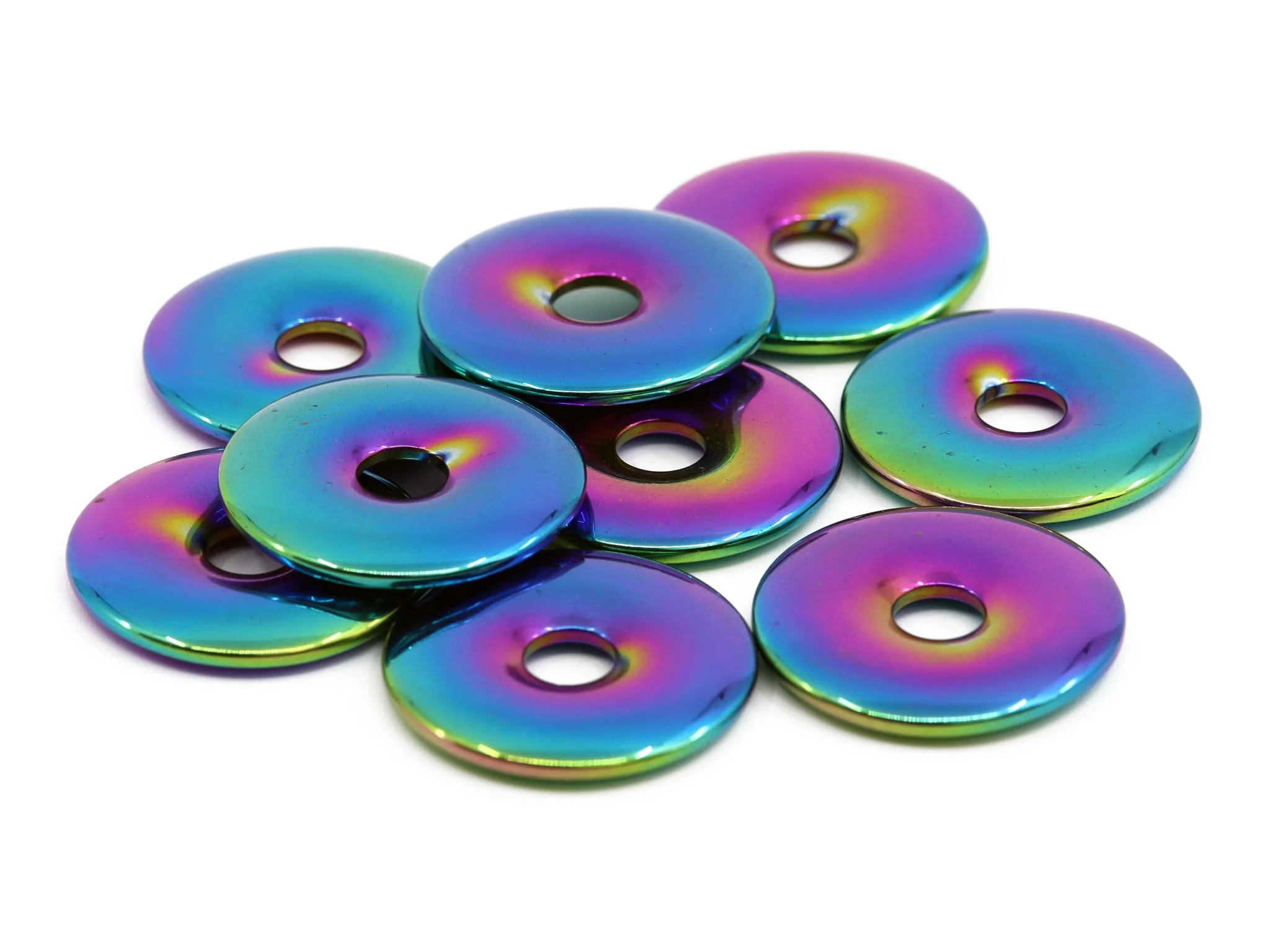Rainbow hematite donuts in multiple iridescent color tones as group view on white background