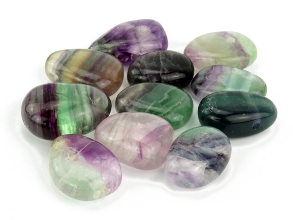 Rainbow fluorite pendant as selection of polished donut stones with individual multicolored grain
