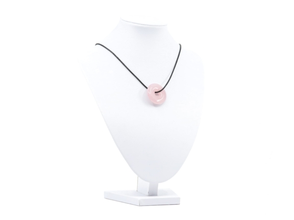Vue du pendentif donut en quartz rose en collier sur un buste à bijoux blanc