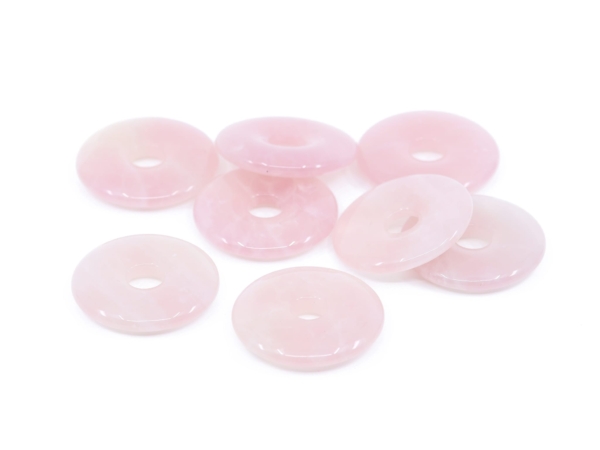 Pendentif donut en quartz rose présentant une sélection de plusieurs pierres percées roses polies