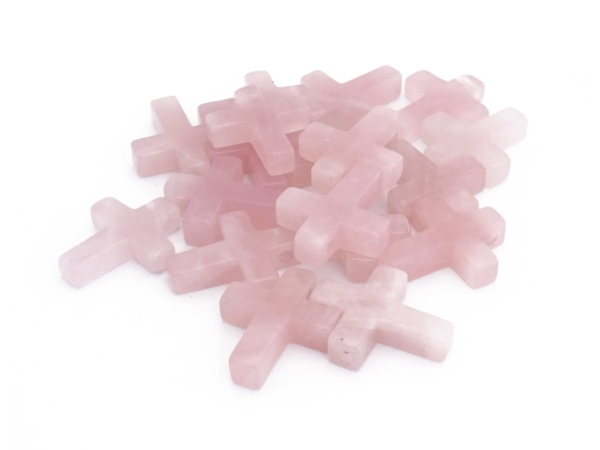 Pendentif croix en quartz rose : sélection de plusieurs croix en pierre rose sur fond blanc