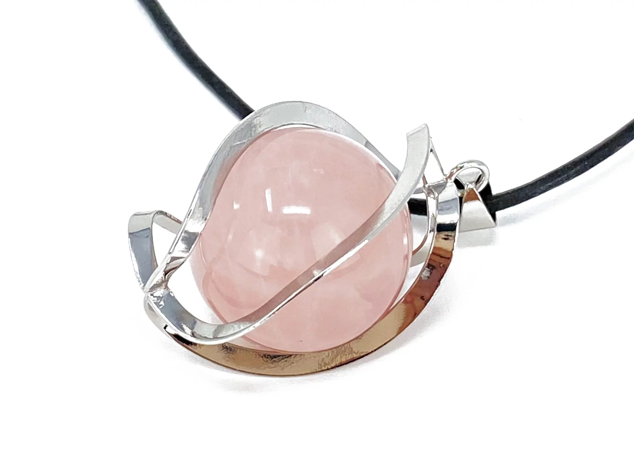 Rose quartz sphere pendant in close-up side view with a silver-colored cage on a white background