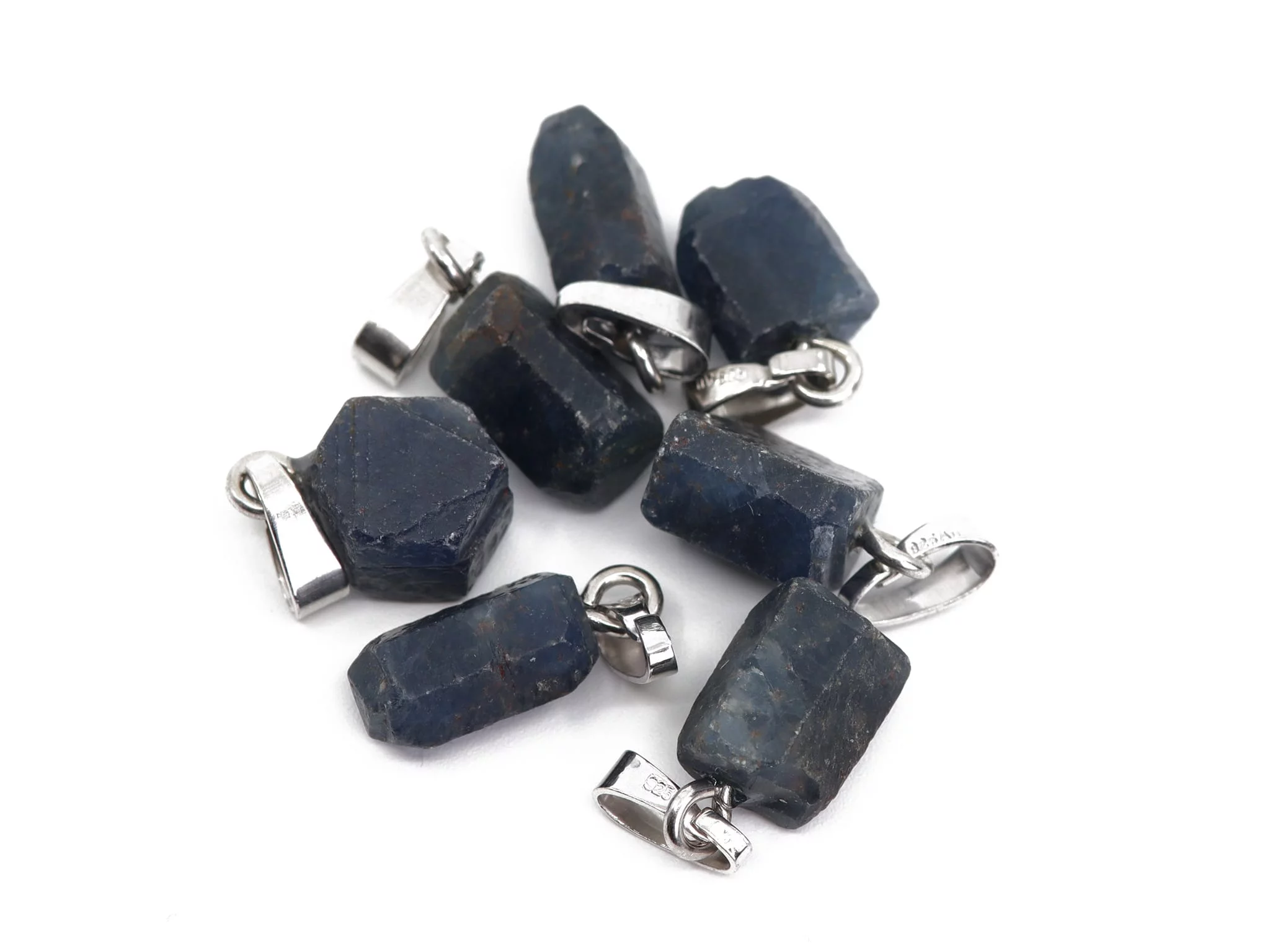 Sapphire natural crystal pendant with shiny 925 silver eyelets in a group view