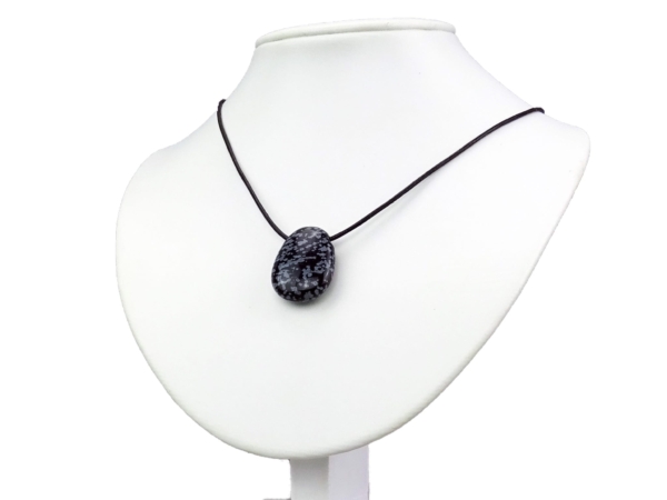 Pendentif en obsidienne flocon de neige sur collier noir, sur buste à bijoux blanc