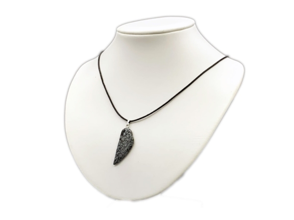Pendentif aile d’ange en obsidienne flocon de neige sur collier noir, sur buste de bijouterie blanc